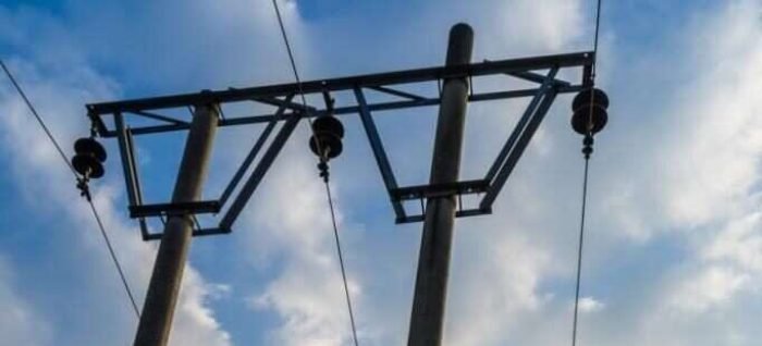 Low Angle View Of telegraph poles against blue sky.
